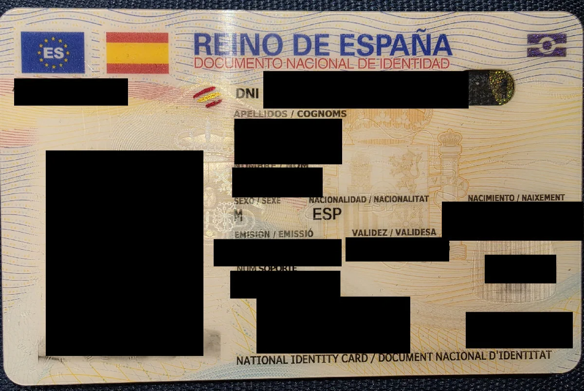 Anverso de un DNI real con los datos identificativos y el rostro tapados con barras negras